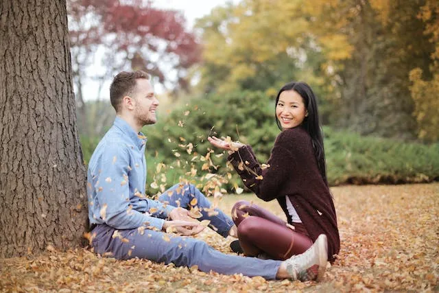 Playing With Leaves pose for Fall Couple Photoshoot Ideas